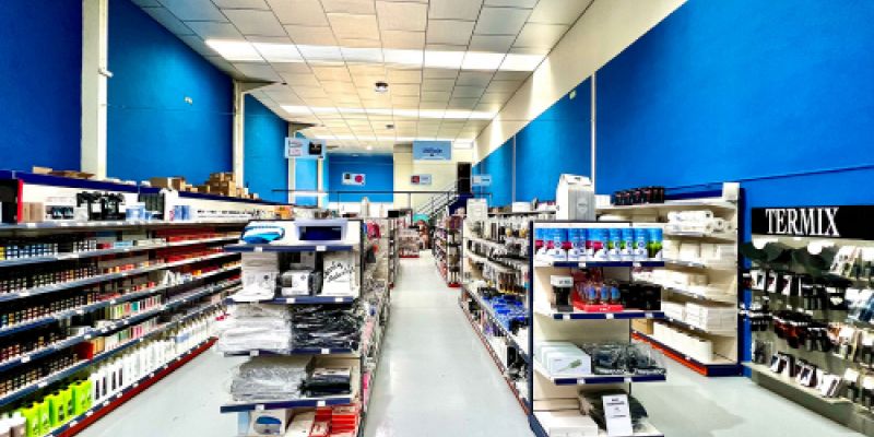 Imagen de interior de almacén con pasillos de paredes azules y estantes con productos