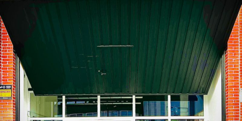 Imagen de puerta de entrada a almacén con nombre de empresa en parte superior