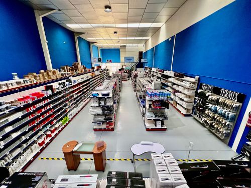 Imagen de interior de almacén con paredes azules y estantes con productos